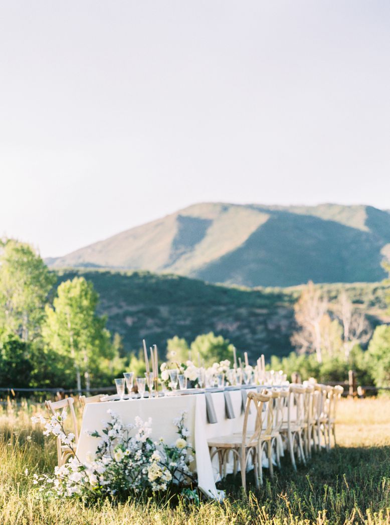 wedding table in grass field and mountain backdrop