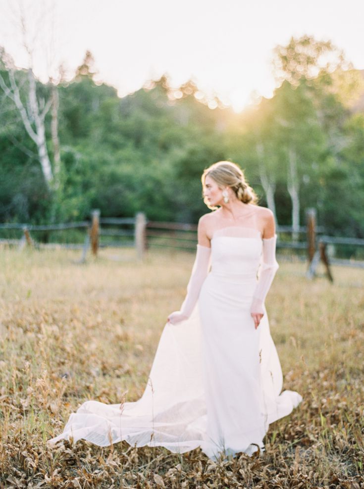 bride with natural makeup and hair posing in grass field