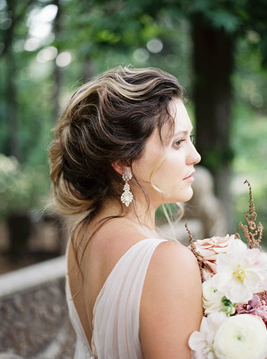 beautiful updo on bride standing in the woods