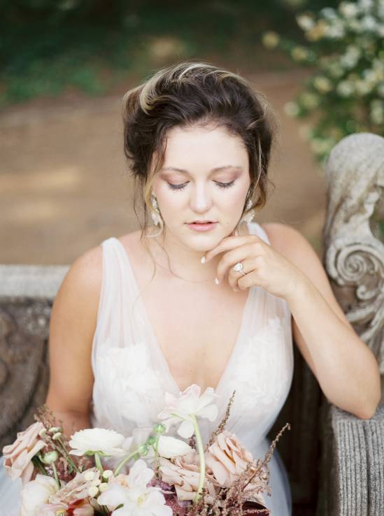 bride in white dress sitting on a bench