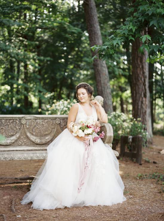bride resting on a bench in the woods