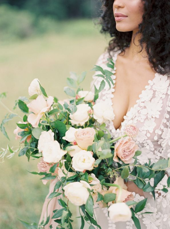 bride holding bouquet standing near flowers