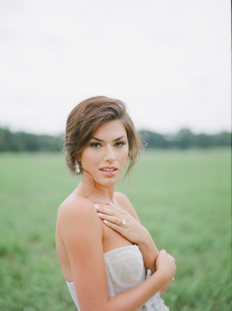 bride looking at camera in grassy field