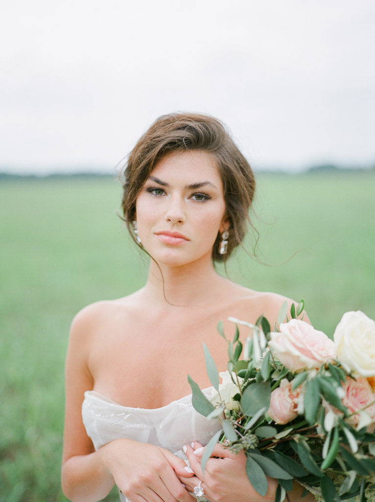 bride with bouquet in grassy field