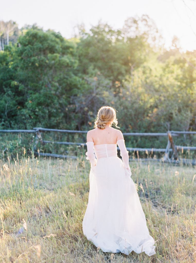 bride in white wedding dress in grass field