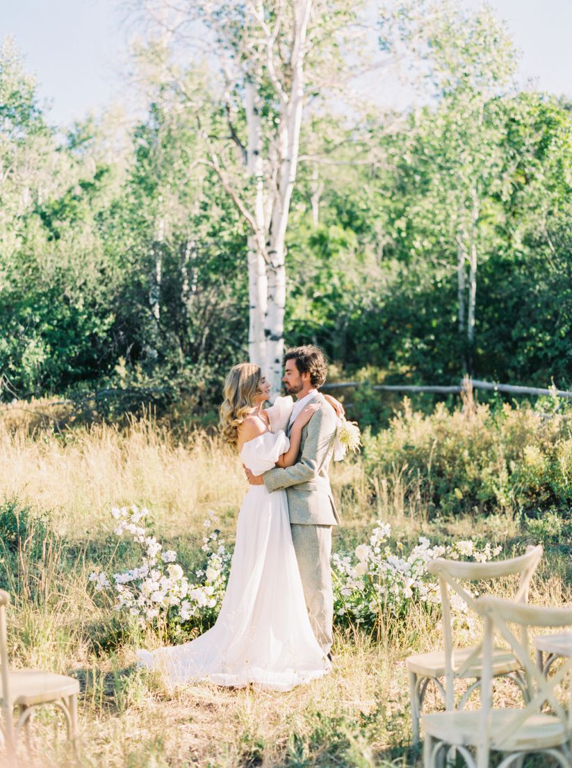 bride and groom embrace in the woods