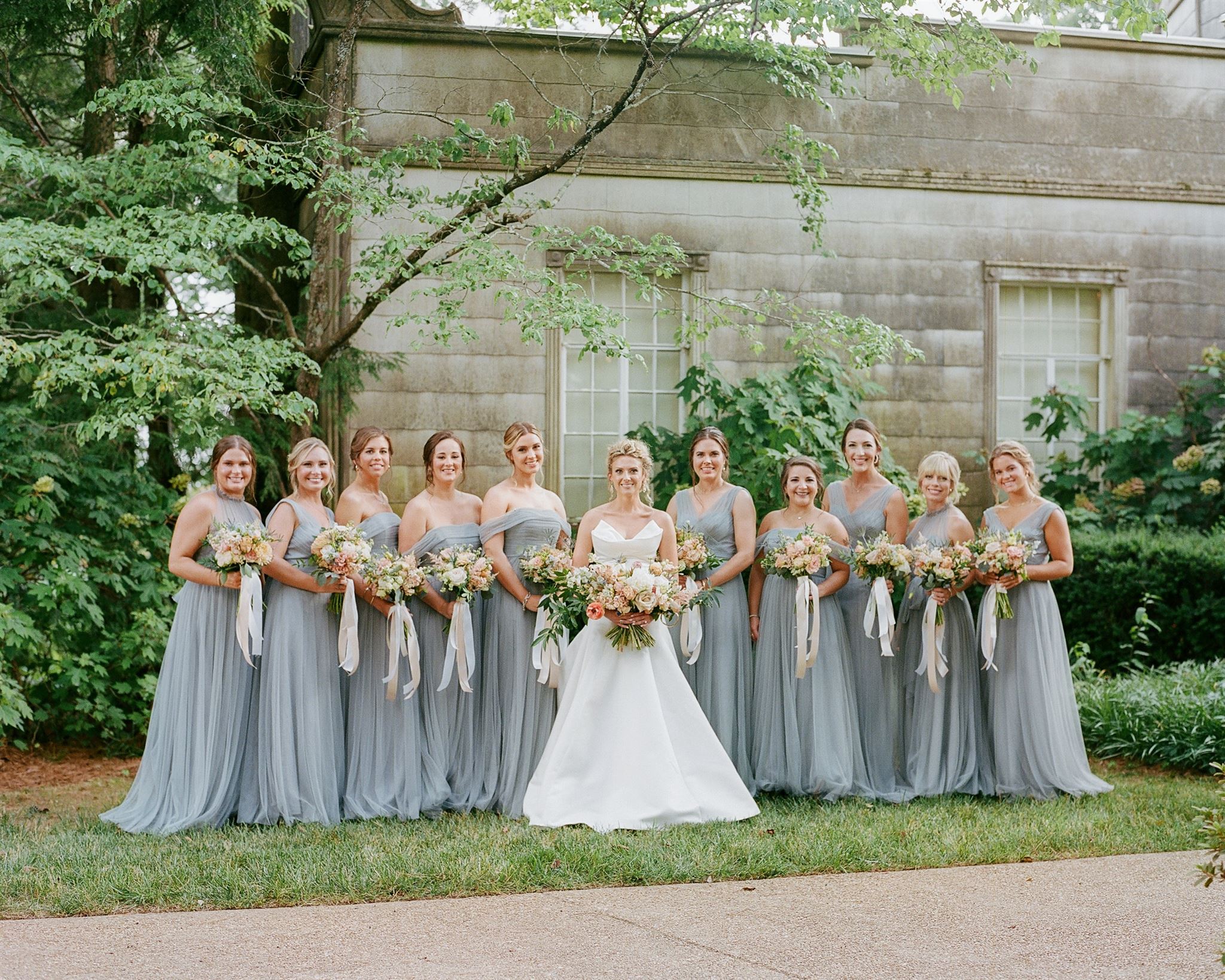 Bride and bridesmaids posing in front of venue