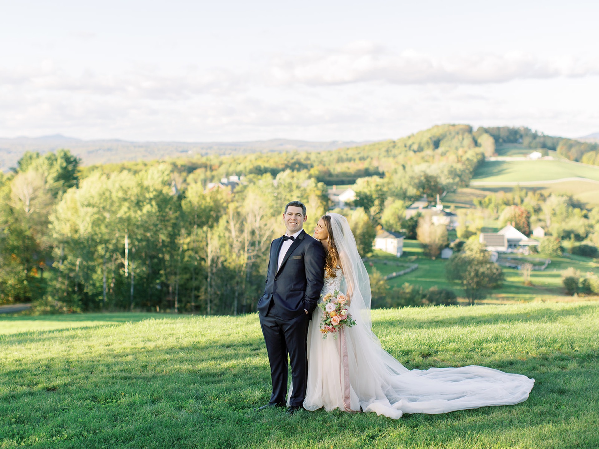 Bride and groom holding hands in a field in Vermont