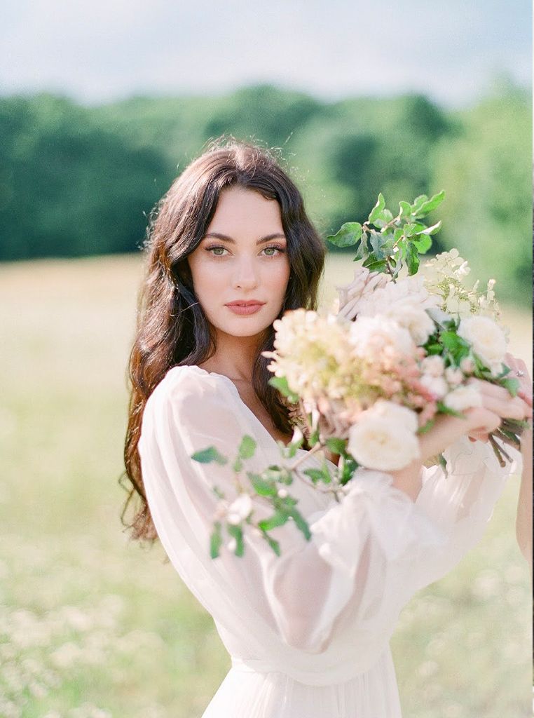bride holding bridal bouqet in grassy field
