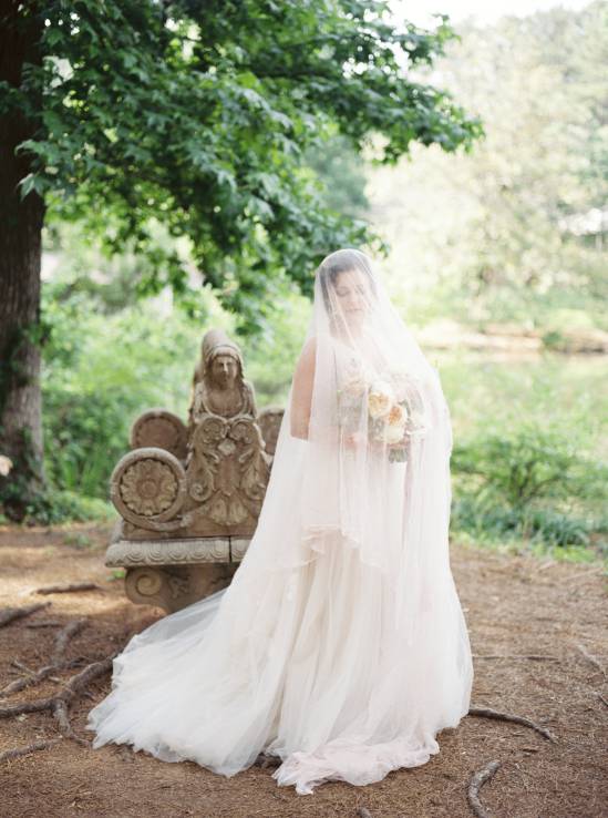 bride draped in white wedding veil