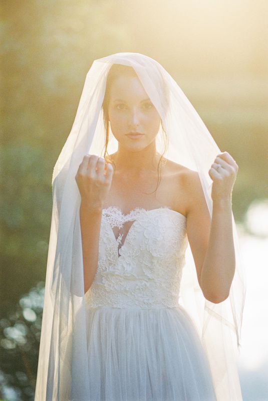 bride holding veil open displaying natural hair and makeup