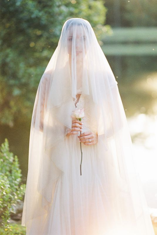 veiled bride holding a single rose