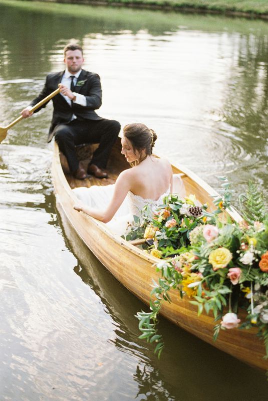bride, bridal bouquet, and groom in a canoe