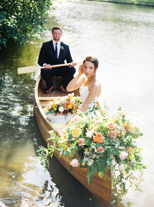 bride and groom rowing in a canoe
