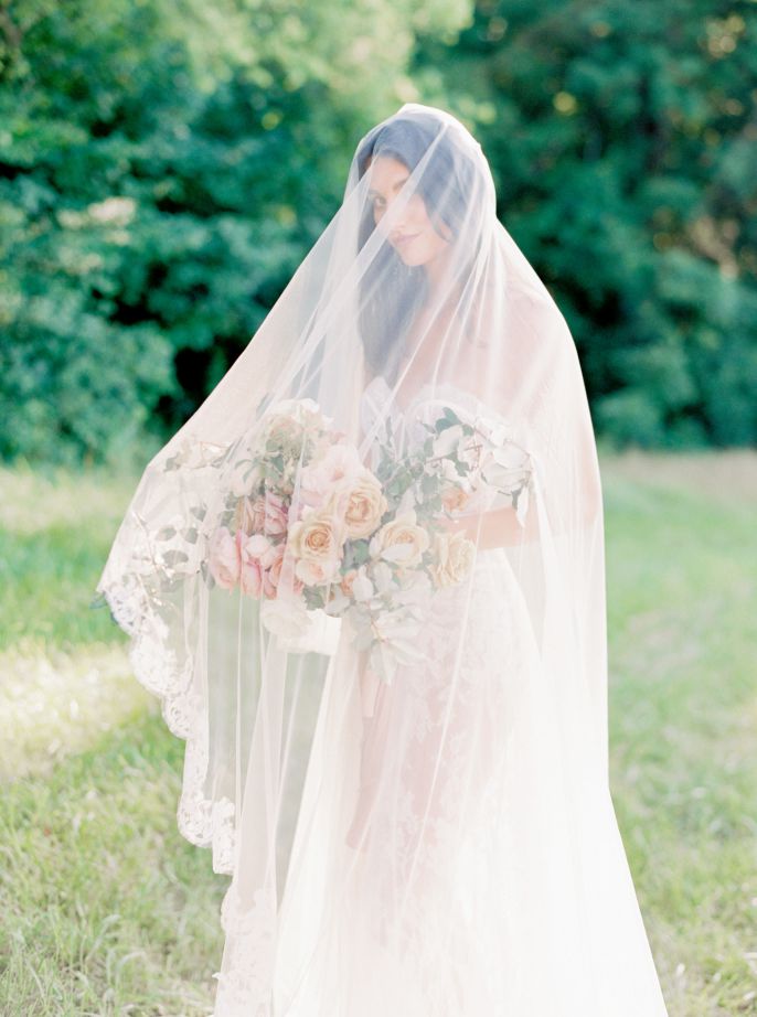 bride draped in white veil