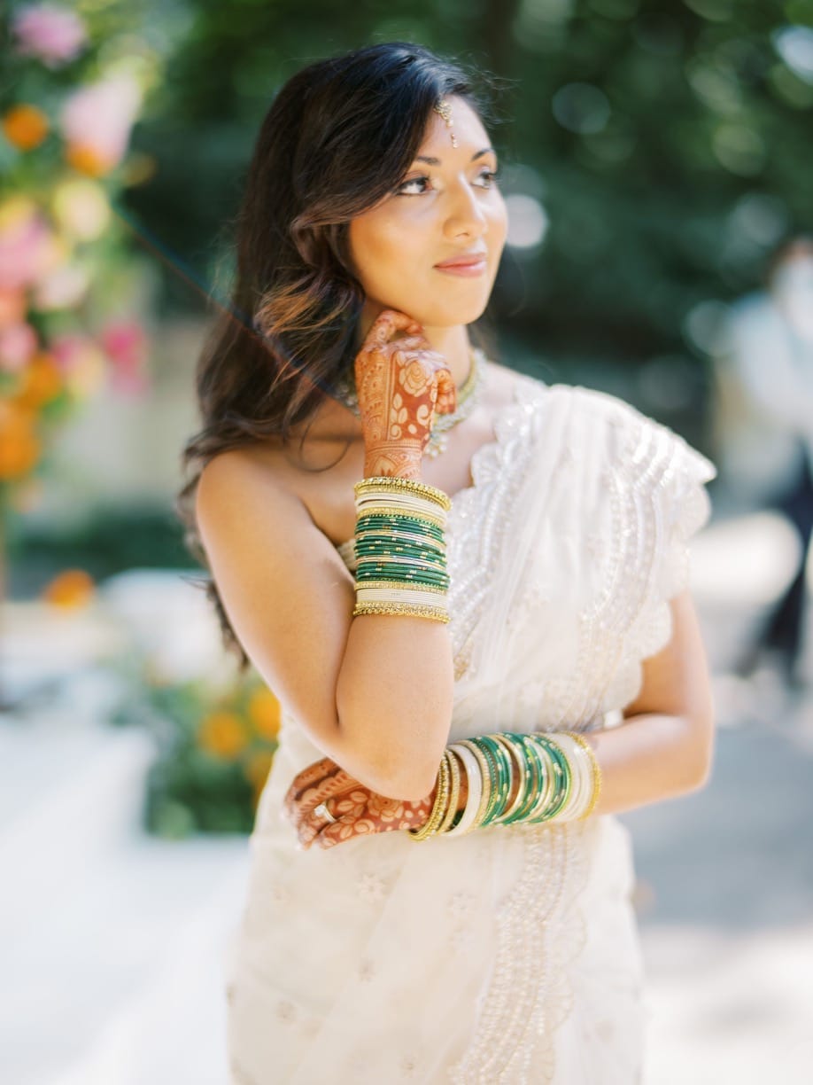 Brunette indian bride posing with bracelets and soft hair and makeup