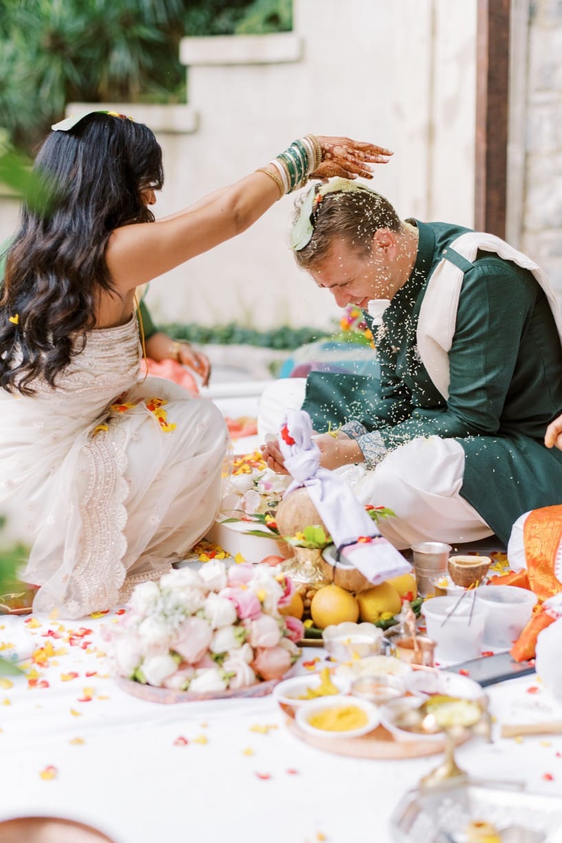 bride sprinkling rice over her husband during the ceremony