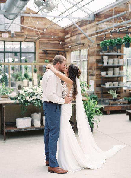 Just married couple hugging and kissing while the bride's hair and veil hang magically