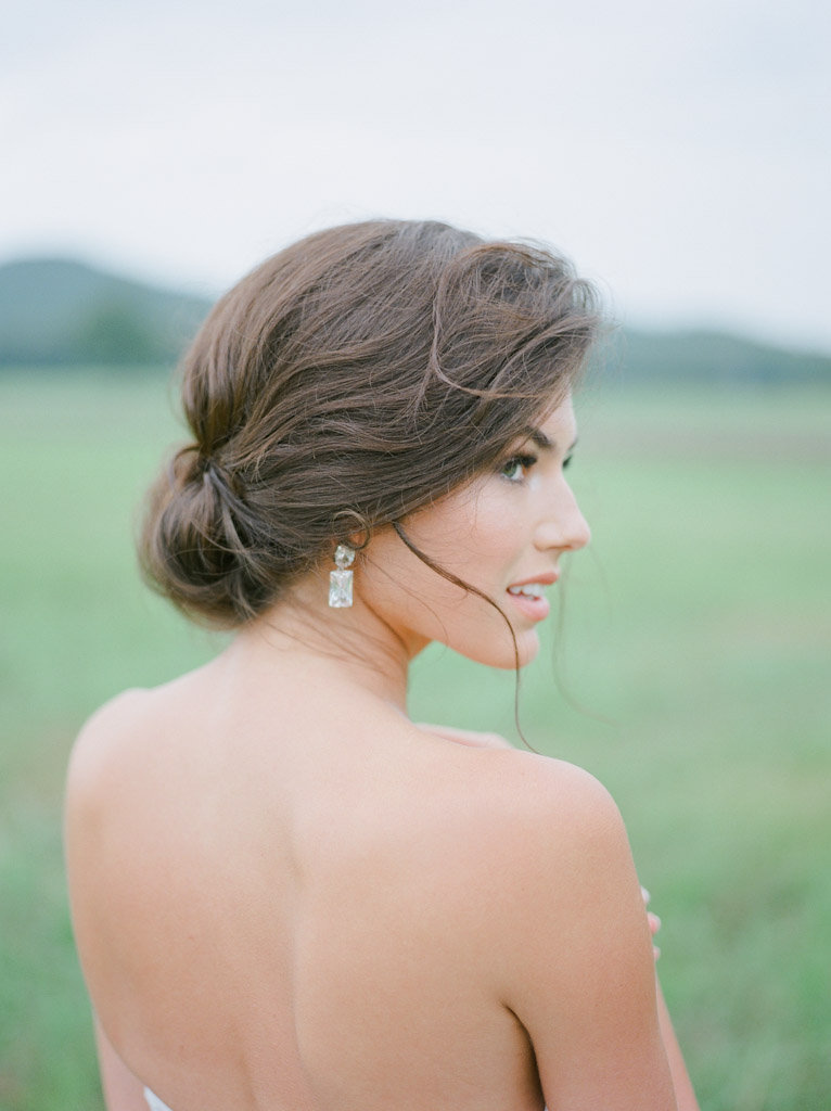 brunette bridal hair styling in grassy field